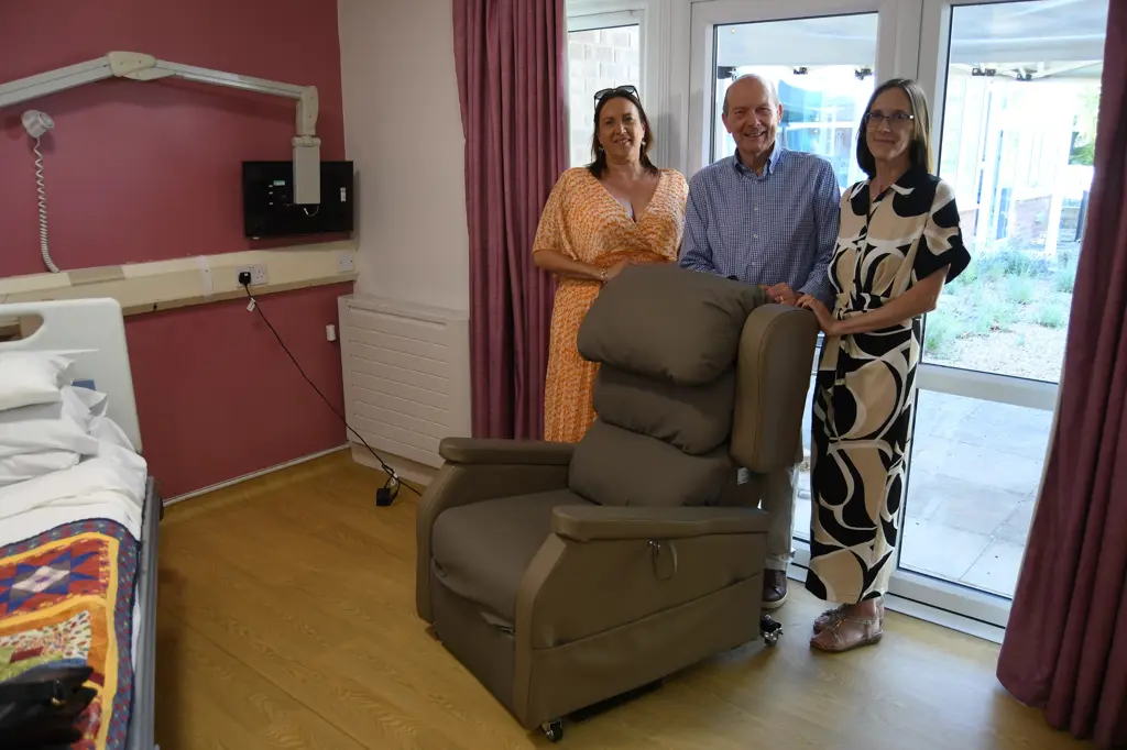 Ian Lawrence and his family pictured with the new therapy chair at Myton Hospice, Warwick. Alt text: Ian Lawrence and his family standing beside the donated therapy chair at Myton Hospice.